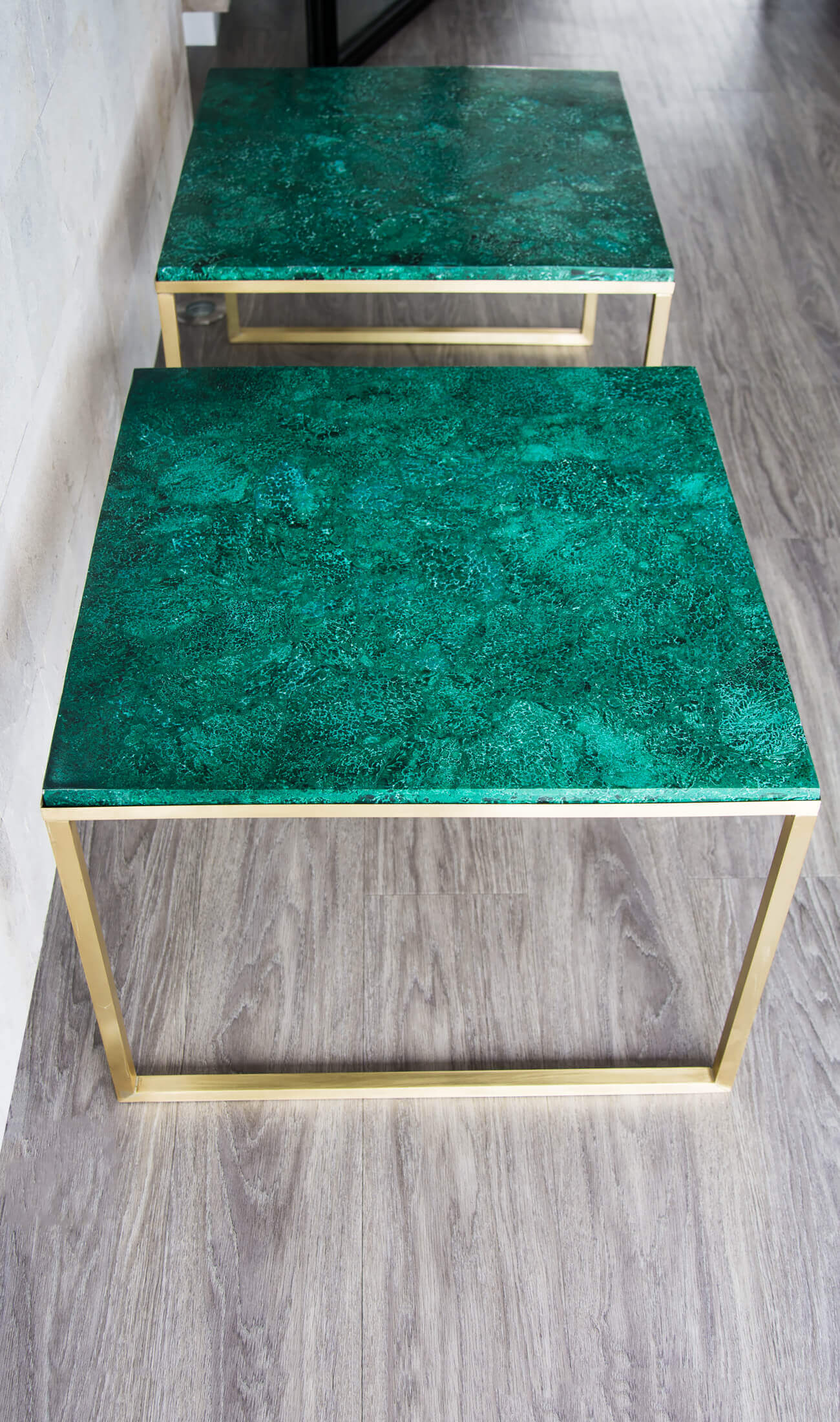 Beautifully curated Malachite tabletops presented on custom designed brass bases by THE FOSSIL STORE